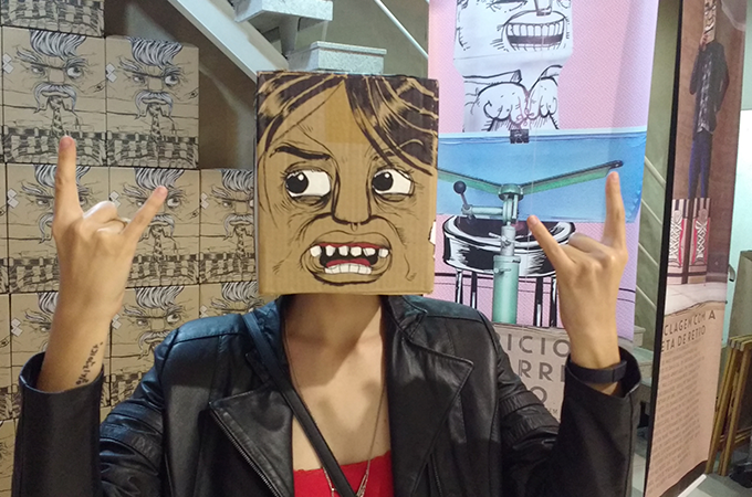 Eu usando um capacete de papelão criado por Bruno Honda, que estava na exposição dele.